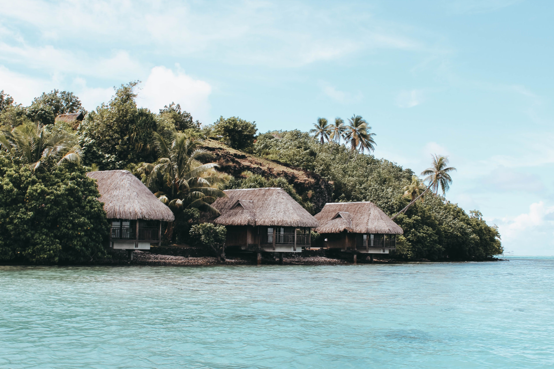 Thatched-roof bungalows along the lagoon shore, French Polynesia