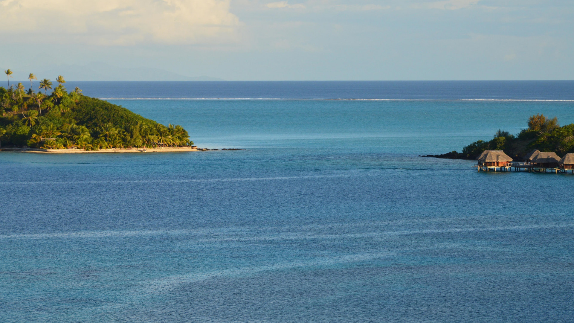 Wooded motu and overwater bungalows facing the lagoon at sunset, Bora Bora — closing image